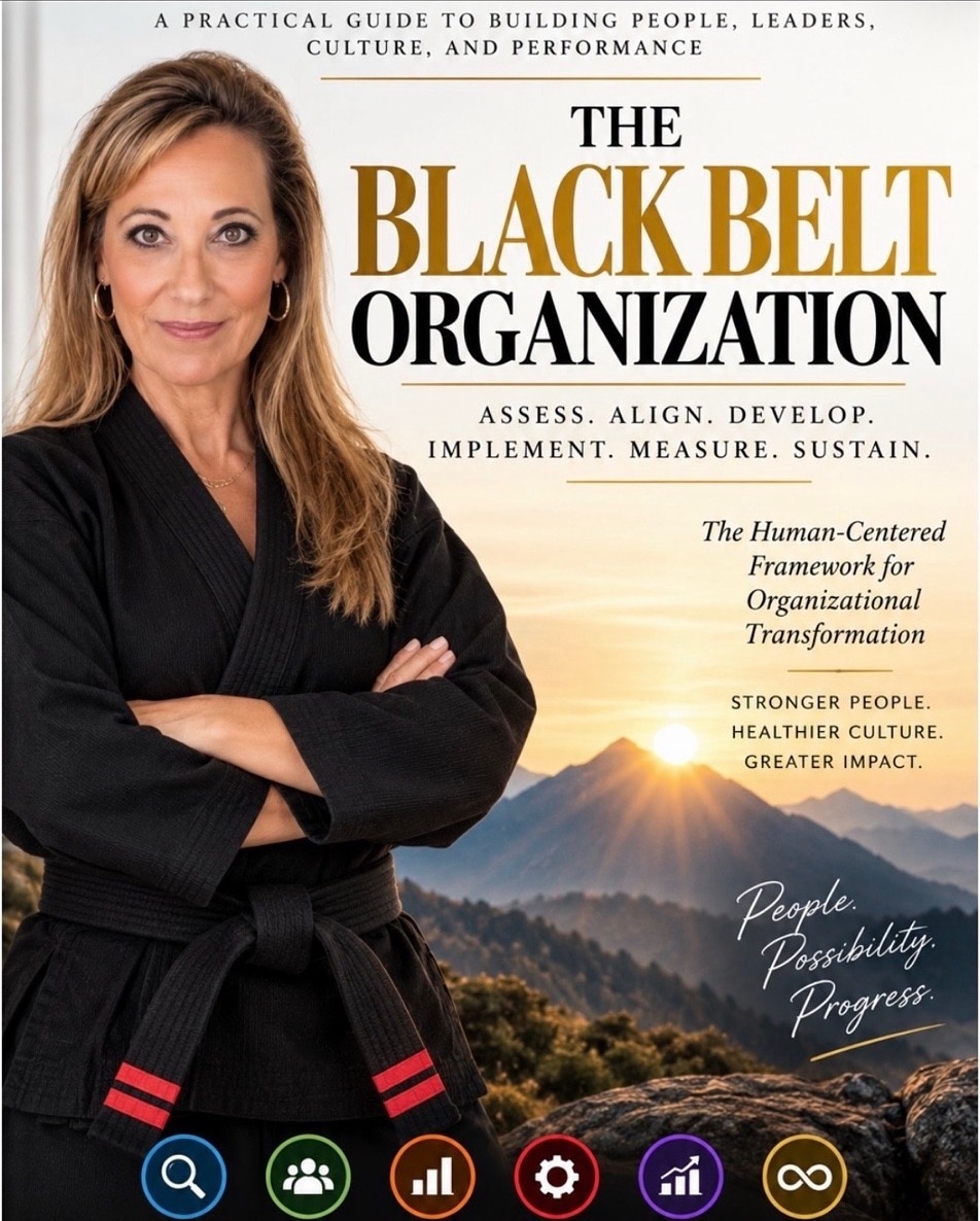 Cover of The Black Belt Organization, showing a woman in a black gi with a black belt crossed over her chest against a mountain range at sunrise